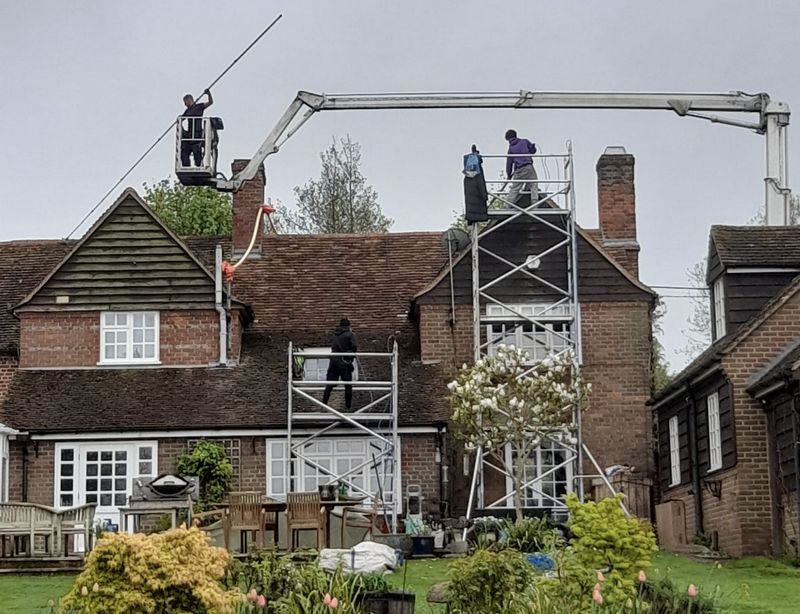 The Moss Cleaners using cherry picker and scaffolding to clean roof safely and professionally in Pewsey, Wiltshire